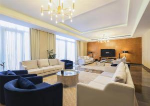 un grand salon avec des canapés et une télévision dans l'établissement Kempinski Al Othman Hotel Al Khobar, à Khobar
