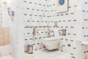 a white bathroom with a toilet and a sink at Kempinski Al Othman Hotel Al Khobar in Al Khobar