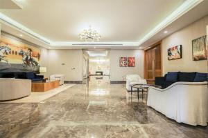a large living room with couches and a chandelier at Kempinski Al Othman Hotel Al Khobar in Al Khobar