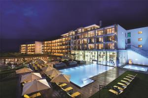 a hotel with a swimming pool in front of a building at Kempinski Hotel Das Tirol in Jochberg