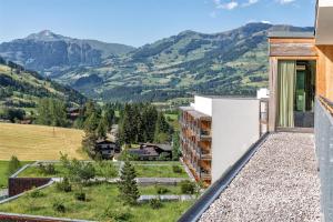 a view of the mountains from the balcony of a building at Kempinski Hotel Das Tirol in Jochberg