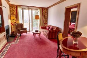 a living room with a couch and a table at Kempinski Hotel Das Tirol in Jochberg