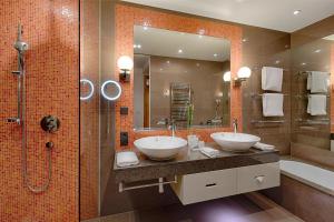 a bathroom with two sinks and a shower at Kempinski Hotel Das Tirol in Jochberg