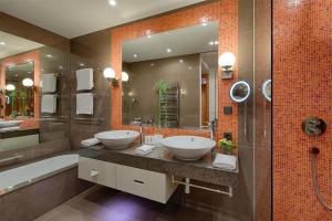 a bathroom with two sinks and a large mirror at Kempinski Hotel Das Tirol in Jochberg