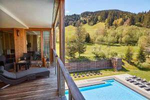 a house with a pool on a deck with a view at Kempinski Hotel Das Tirol in Jochberg