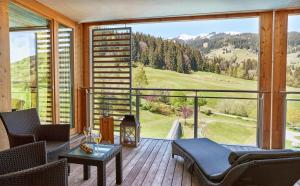 a room with a balcony with a view of the mountains at Kempinski Hotel Das Tirol in Jochberg