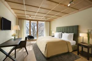 a hotel room with a bed and a desk and a desk at Kempinski Hotel Das Tirol in Jochberg