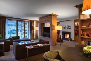 a living room with a couch and a tv at Kempinski Hotel Das Tirol in Jochberg