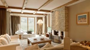 a living room with white furniture and a fireplace at Kempinski Hotel Das Tirol in Jochberg