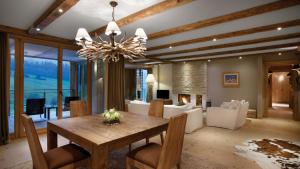 a dining room with a table and a chandelier at Kempinski Hotel Das Tirol in Jochberg