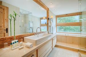 a bathroom with a sink and a large mirror at Kempinski Hotel Das Tirol in Jochberg