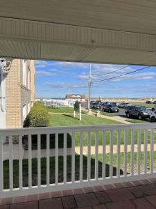 a white porch with a view of a parking lot at Beautiful Bradley Beach Views, Unbeatable Dream Porch, New Grill, 6 Badges in Bradley Beach +8 photos