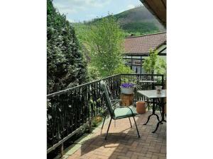 eine Terrasse mit einem Tisch und einem Stuhl auf dem Balkon in der Unterkunft Holiday home in Harz with 2 bedrooms in Ilsenburg