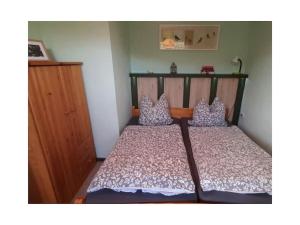 ein kleines Schlafzimmer mit einem Bett mit einem Kopfteil aus Holz in der Unterkunft Holiday home in Harz with 2 bedrooms in Ilsenburg