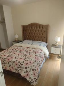 a bedroom with a bed with a floral bedspread at Moderno departamento con vista panorámica cerca a los centros comerciales in Lima