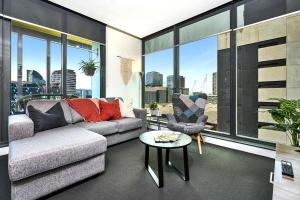 a living room with a couch and a table at Spencer St Serenity Stylish Urban Escape in the CBD in Melbourne