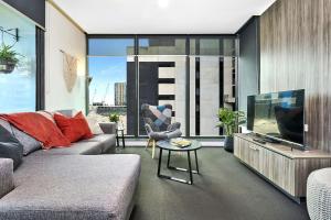 a living room with a couch and a flat screen tv at Spencer St Serenity Stylish Urban Escape in the CBD in Melbourne