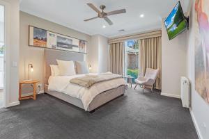 a bedroom with a bed and a flat screen tv at Blair Street - Luxury Home with Pool and Theatre in Moama +16 photos