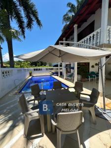 メルガルにあるCasa Quinta Melgarのテーブルと椅子と傘のあるパティオ