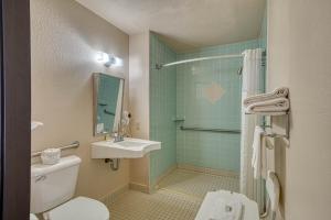 a bathroom with a sink and a toilet and a shower at Super 8 by Wyndham Sturgis in Sturgis +28 photos