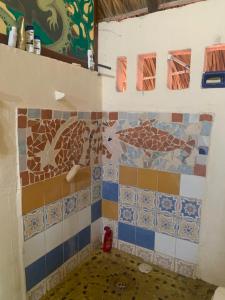 a bathroom with colorful tiles on the wall at Columpio del Reptil cabaña in Mazunte