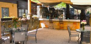 a patio with tables and chairs and a bar at Hotel Boutique Bacaanda in Tepoztlán