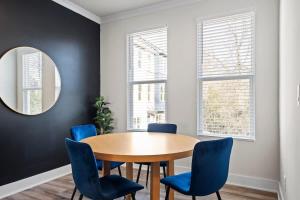 a dining room with a wooden table and blue chairs at Luxurious King 3BR Townhouse Mins to Uptown CLT! in Charlotte