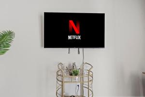 a tv hanging on a wall next to a plant at Luxurious King 3BR Townhouse Mins to Uptown CLT! in Charlotte +17 photos