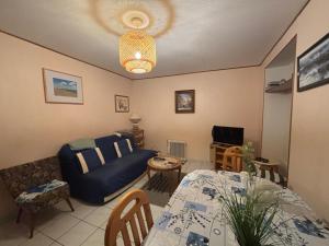 un salon avec un canapé bleu et une table dans l'établissement Appartement lumineux et proche plage aux Sables-d'Olonne - FR-1-197-446, à Les Sables-dʼOlonne