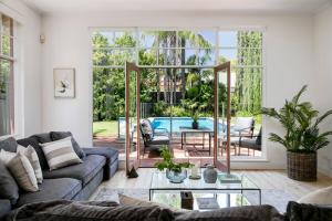 ein Wohnzimmer mit einer Couch und einem Glastisch in der Unterkunft Oasis - Luxe living, with pool - walk to cafes in Rose Park