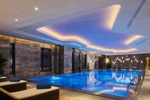 a swimming pool in a hotel with a ceiling at Wanda Realm Longyan in Longyan