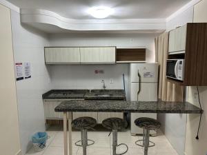 a kitchen with a counter and stools in it at Lacqua diroma I - II - III - IV - V - CN M in Caldas Novas