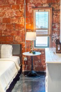 a bedroom with a bed and a table with a lamp at The Secret Cenote Hotel in Jacksonville
