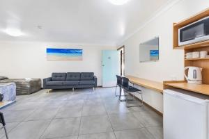a living room with a couch and a table at Palm Valley Motel in Tarro