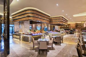 a restaurant with tables and chairs in a building at Wanda Realm Longyan in Longyan