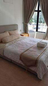 a bed in a bedroom with a large window at Auliya Homestay Melaka Seaview Pantai Puteri in Malacca +17 photos