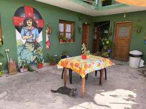 a cat laying next to a table in a room at Casa Clarita in Tilcara