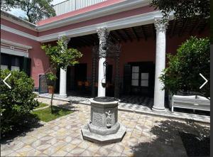 a building with a fountain in the middle of a courtyard at Las Flores in San Isidro