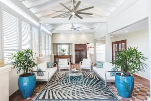 a living room with two potted plants and a ceiling at Beachfront Luxury 2BR-Villa Acqua Rio Mar in Carmelita