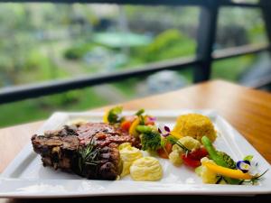 a plate of food with meat and vegetables on a table at Avinka Grand in Talagala