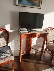 a wooden table with a television on top of it at Acogedor apartamento vista al mar in Iquique