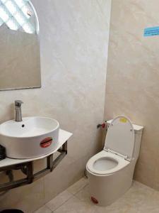 a bathroom with a white toilet and a sink at Khách sạn Tân Cửu Long in Bình Chánh