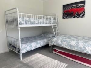 a bedroom with two bunk beds and a bed at Dolphin Drift 29 Dolphin Avenue in Carrickalinga