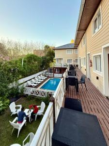 a deck with a pool and two people sitting at tables at Valeria Costa y Mar in Valeria del Mar +42 photos