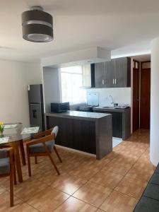 a large kitchen with a table and a counter top at Apart Marchelo 2 in San Antonio