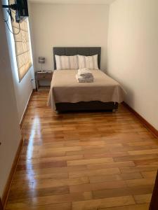 a bedroom with a bed and a wooden floor at Apart Marchelo 2 in San Antonio