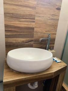 a white sink on a wooden counter in a bathroom at Apart Marchelo 2 in San Antonio