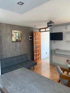 a living room with a blue couch and a table at Apart Marchelo 2 in San Antonio