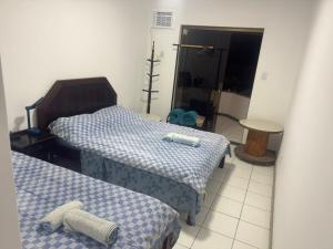 a bedroom with two beds and a teddy bear on the floor at Village Pedra do Sal Lounge Apts in Salvador