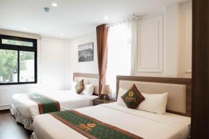a hotel room with two beds and a window at AS Hotel Đà Lạt in Da Lat +25 photos